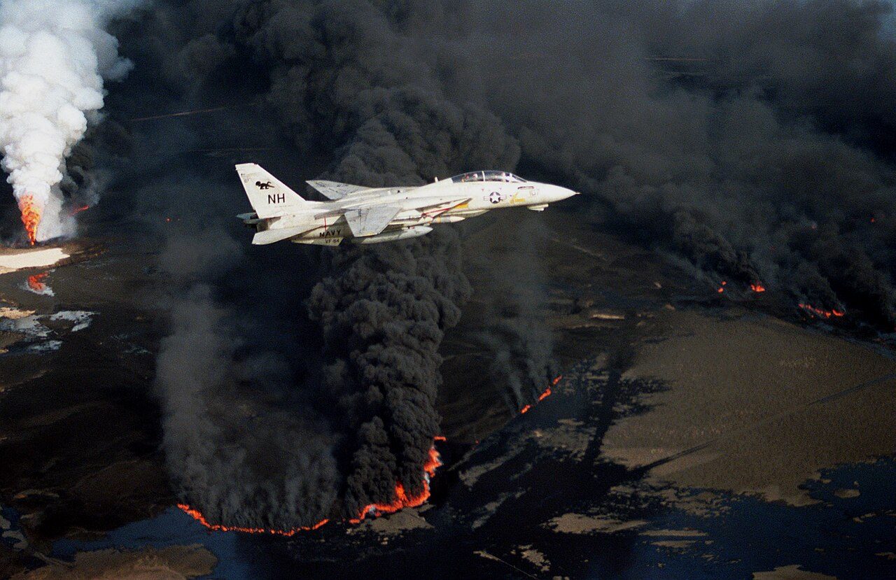 A US Navy jet flying over burning Kuwaiti oil wells in 1991